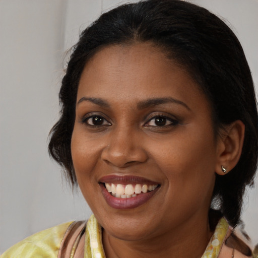 Joyful black young-adult female with medium  brown hair and brown eyes