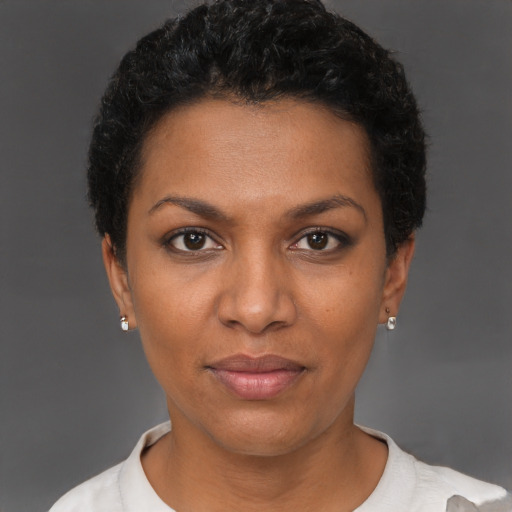 Joyful black young-adult female with short  black hair and brown eyes