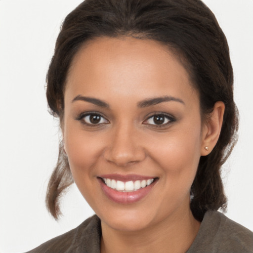 Joyful latino young-adult female with long  brown hair and brown eyes