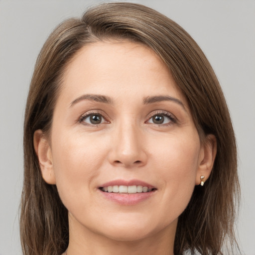 Joyful white young-adult female with medium  brown hair and grey eyes