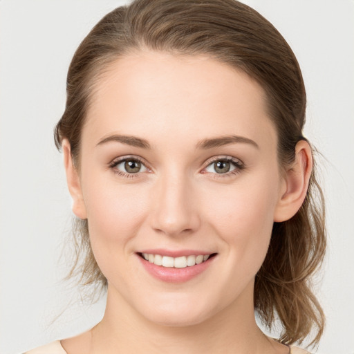 Joyful white young-adult female with medium  brown hair and grey eyes