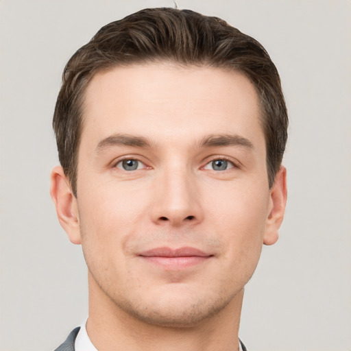 Joyful white young-adult male with short  brown hair and grey eyes