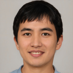 Joyful asian young-adult male with short  brown hair and brown eyes