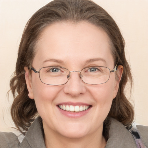 Joyful white adult female with medium  brown hair and blue eyes