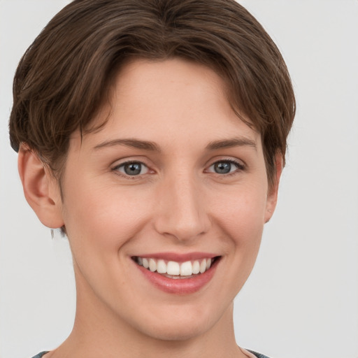 Joyful white young-adult female with short  brown hair and grey eyes