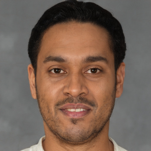 Joyful latino young-adult male with short  brown hair and brown eyes