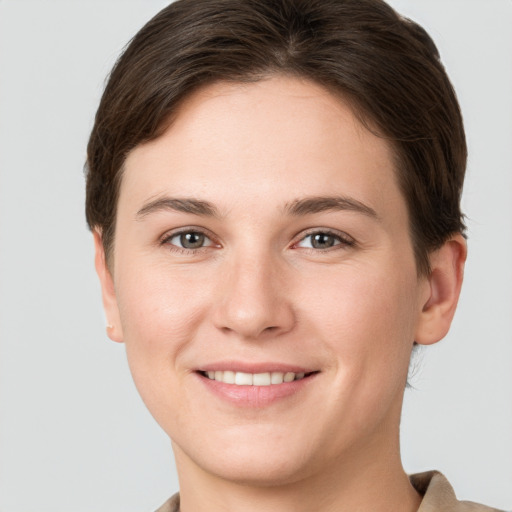 Joyful white young-adult female with short  brown hair and grey eyes