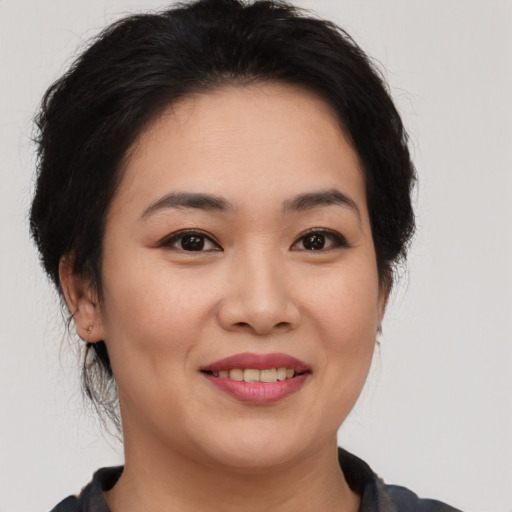 Joyful asian young-adult female with short  brown hair and brown eyes