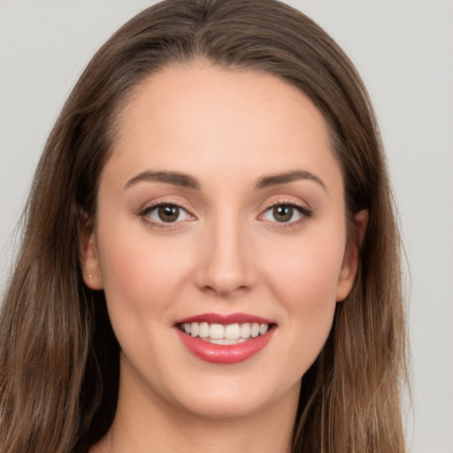 Joyful white young-adult female with long  brown hair and brown eyes