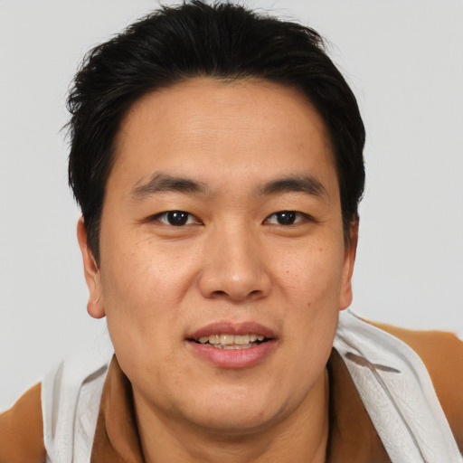 Joyful asian young-adult male with short  brown hair and brown eyes