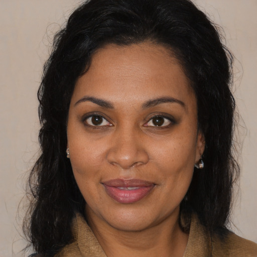 Joyful black young-adult female with long  brown hair and brown eyes