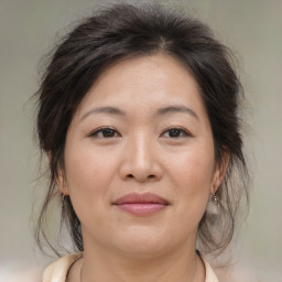 Joyful asian adult female with medium  brown hair and brown eyes