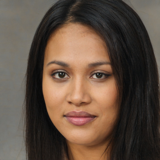 Joyful black young-adult female with long  brown hair and brown eyes