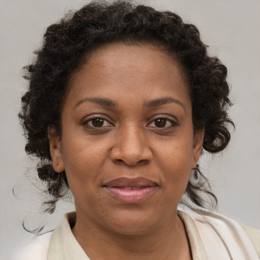 Joyful black adult female with short  brown hair and brown eyes