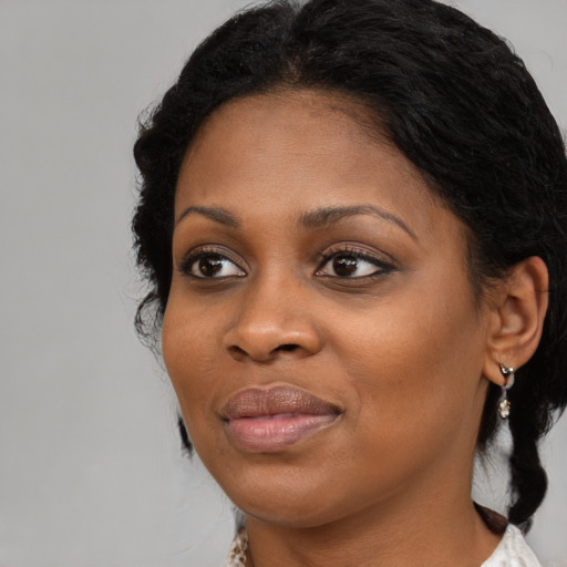 Joyful black young-adult female with medium  black hair and brown eyes