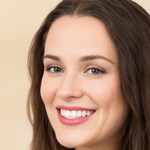 Joyful white young-adult female with long  brown hair and brown eyes