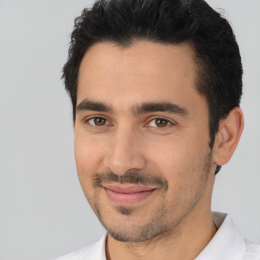 Joyful white young-adult male with short  black hair and brown eyes