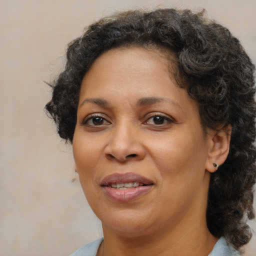 Joyful black adult female with medium  brown hair and brown eyes