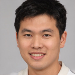 Joyful asian young-adult male with short  brown hair and brown eyes