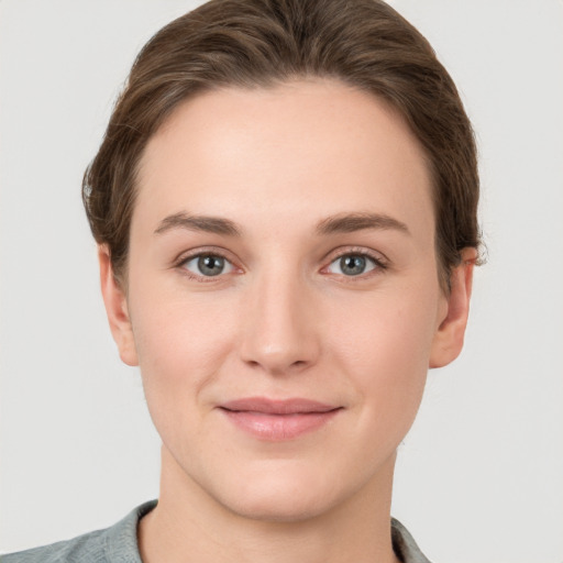 Joyful white young-adult female with short  brown hair and grey eyes