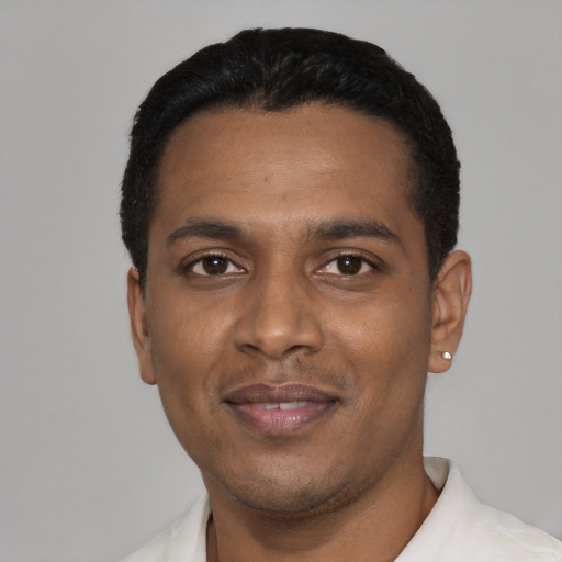 Joyful black young-adult male with short  black hair and brown eyes