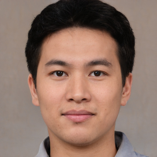 Joyful asian young-adult male with short  black hair and brown eyes