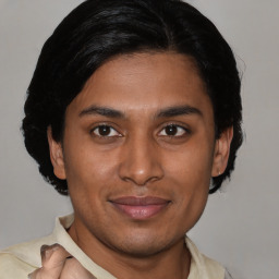 Joyful latino young-adult male with short  brown hair and brown eyes