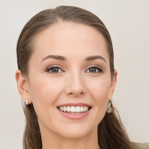 Joyful white young-adult female with long  brown hair and grey eyes