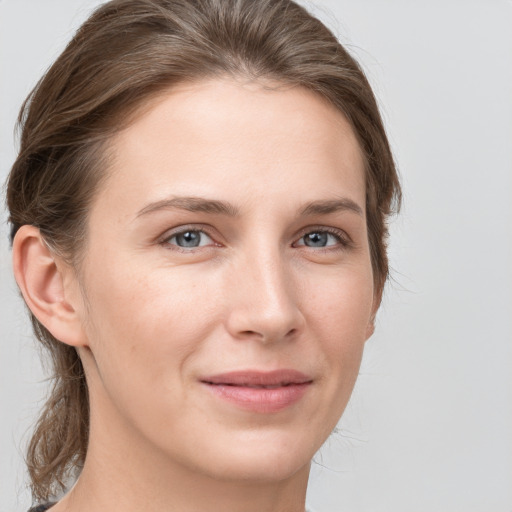 Joyful white young-adult female with medium  brown hair and grey eyes