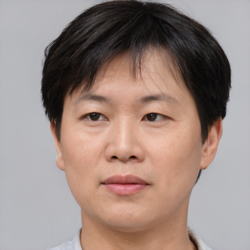 Joyful asian adult male with short  brown hair and brown eyes