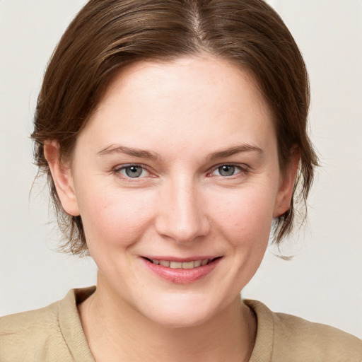 Joyful white young-adult female with medium  brown hair and grey eyes