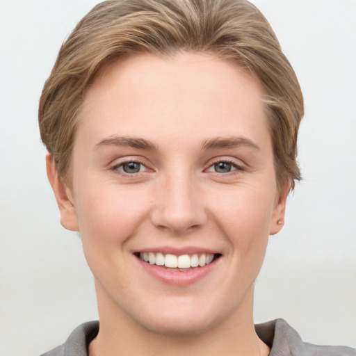 Joyful white young-adult female with short  brown hair and grey eyes