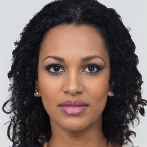 Joyful black young-adult female with long  black hair and brown eyes