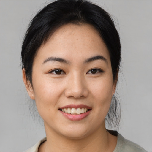 Joyful asian young-adult female with medium  brown hair and brown eyes