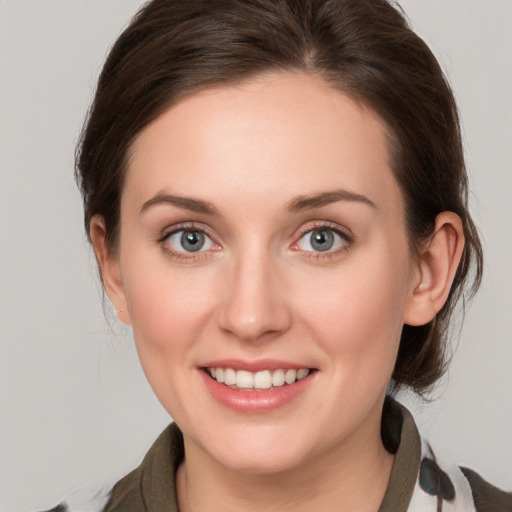 Joyful white young-adult female with medium  brown hair and grey eyes