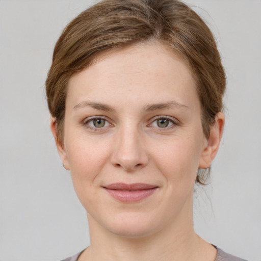 Joyful white young-adult female with short  brown hair and grey eyes