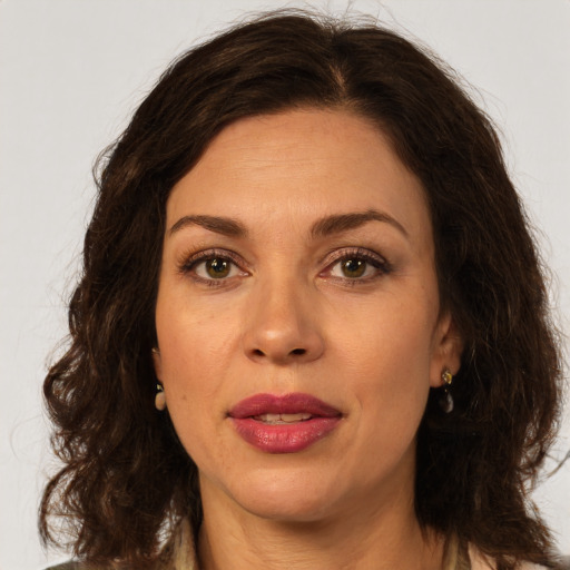 Joyful white adult female with long  brown hair and brown eyes