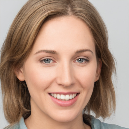 Joyful white young-adult female with medium  brown hair and grey eyes