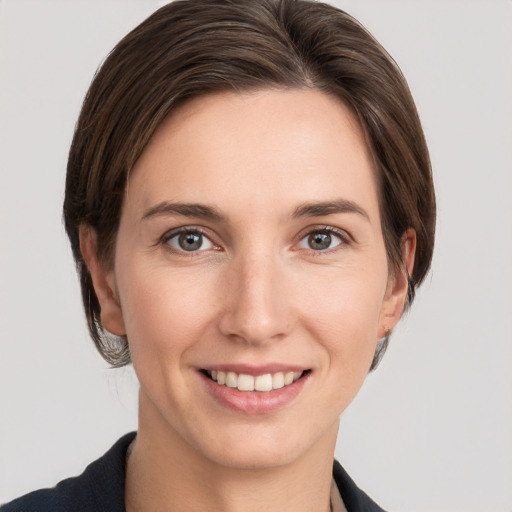 Joyful white young-adult female with medium  brown hair and grey eyes