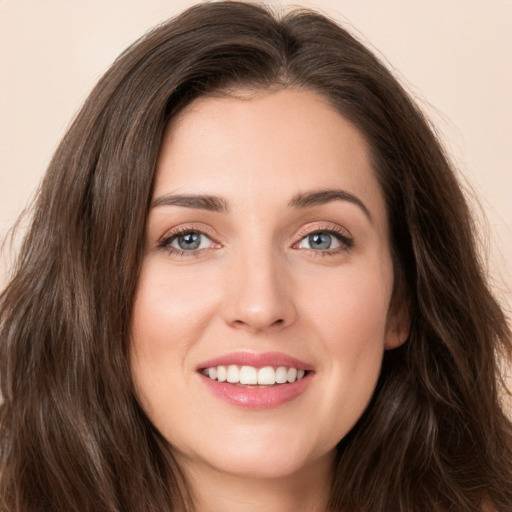 Joyful white young-adult female with long  brown hair and green eyes