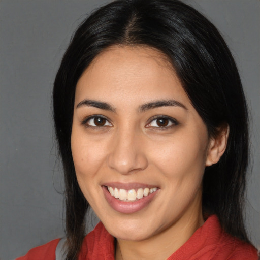 Joyful latino young-adult female with long  black hair and brown eyes