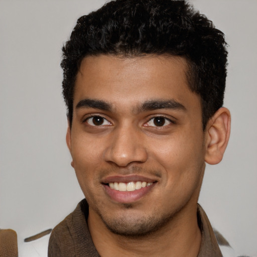 Joyful latino young-adult male with short  black hair and brown eyes