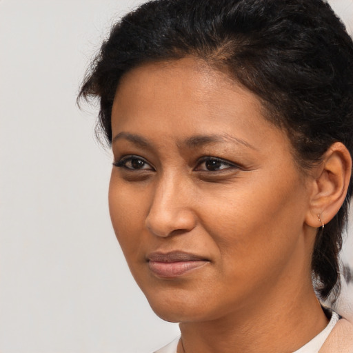 Joyful black young-adult female with medium  brown hair and brown eyes