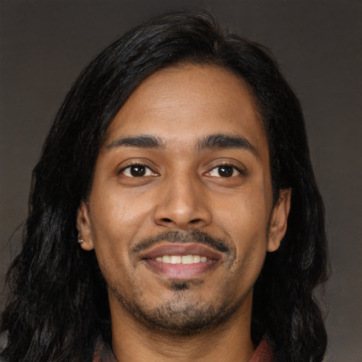Joyful latino young-adult male with long  black hair and brown eyes