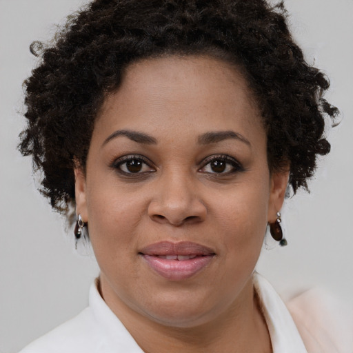 Joyful black young-adult female with short  brown hair and brown eyes