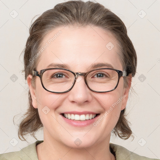 Joyful white adult female with medium  brown hair and blue eyes