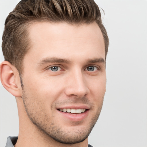 Joyful white young-adult male with short  brown hair and grey eyes