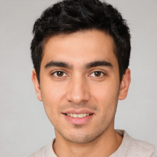 Joyful white young-adult male with short  black hair and brown eyes