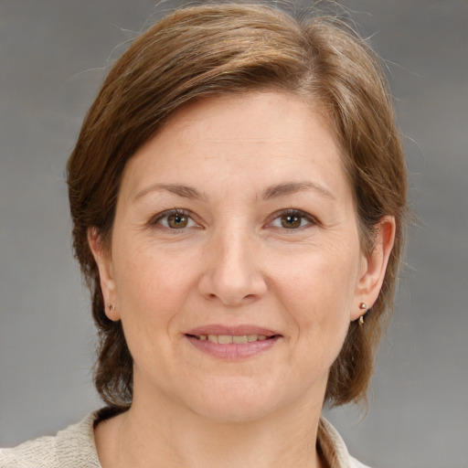 Joyful white adult female with medium  brown hair and blue eyes