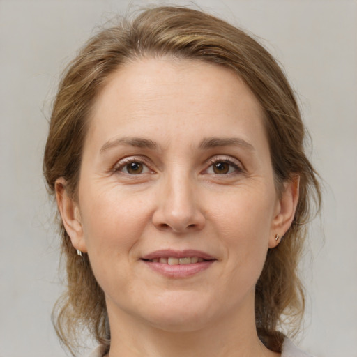 Joyful white adult female with medium  brown hair and grey eyes